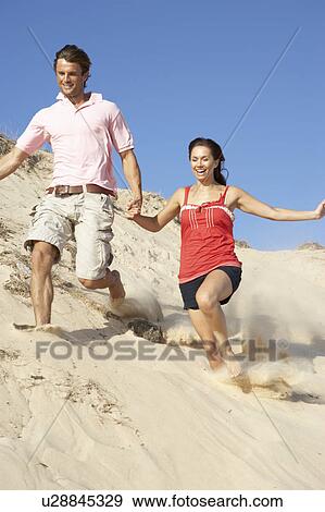Couple Enjoying Beach Holiday Running Down Dune View Large Photo Image Stock Photo - Couple Enjoying Beach Holiday Running Down Dune. Fotosearch