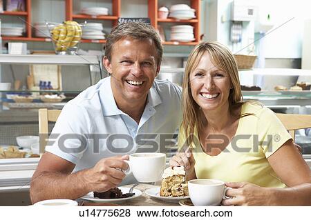 Stock Photo - Couple Enjoying Slice Of Cake And Coffee In Café . Fotosearch