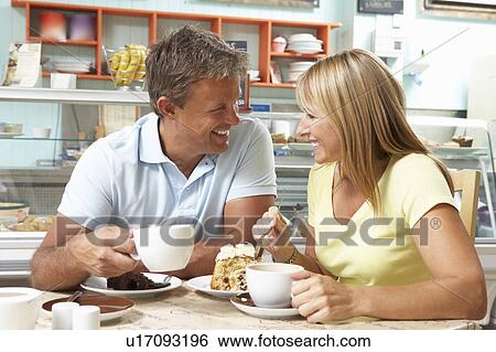 Stock Photograph - Couple Enjoying Slice Of Cake And Coffee In Café . Fotosearch