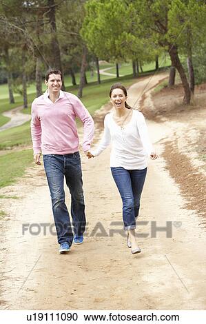 Stock Image - Couple enjoying walk in park. Fotosearch