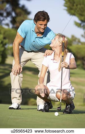 Couple Golfing On Golf Course Lining Up Putt On Green View Large Photo Image Stock Image - Couple Golfing On Golf Course Lining Up Putt On Green. Fotosearch