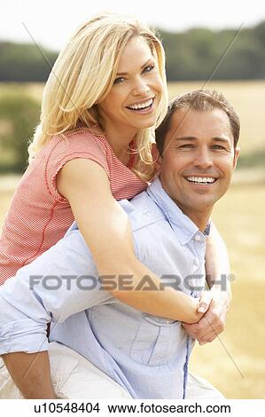 Couple Having Piggyback In Summer Harvested Field View Large Photo Image Picture - Couple Having Piggyback In Summer Harvested Field. Fotosearch