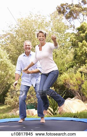 Couple Jumping On Trampoline In Garden View Large Photo Image Stock Photography - Couple Jumping On Trampoline In Garden. Fotosearch