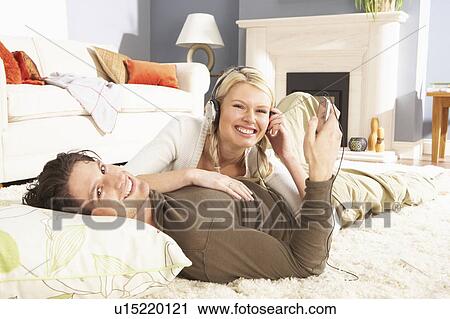 Couple Listening To MP3 Player On Headphones Relaxing Laying On Rug At Home View Large Photo Image Stock Image - Couple Listening To MP3 Player On Headphones Relaxing Laying On Rug At Home . Fotosearch