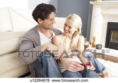 Stock Photo - Couple Looking At Pictures On Digital Camera At Home . Fotosearch