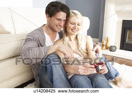 Couple Looking At Pictures On Digital Camera At Home View Large Photo Image Stock Photography - Couple Looking At Pictures On Digital Camera At Home . Fotosearch
