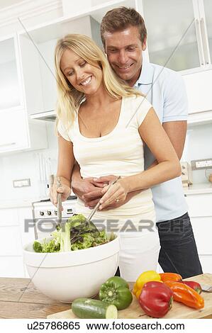 Stock Photography - Couple Preparing Salad In Modern Kitchen. Fotosearch