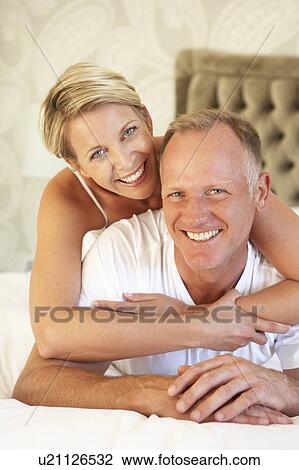 Stock Image - Couple Relaxing In Bedroom. Fotosearch