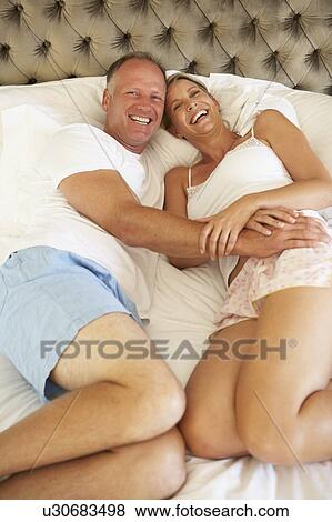 Stock Photo - Couple Relaxing In Bedroom. Fotosearch