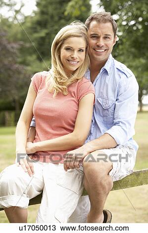 Couple Relaxing In Countryside Sitting On Fence View Large Photo Image Stock Image - Couple Relaxing In Countryside Sitting On Fence. Fotosearch