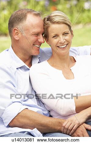 Stock Image - Couple Relaxing In Garden. Fotosearch