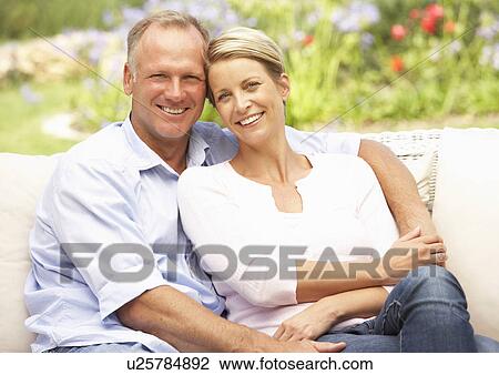 Stock Image - Couple Relaxing In Garden. Fotosearch