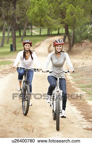Stock Image - Couple riding bicycle in park. Fotosearch