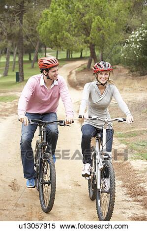 Couple riding bicycle in park View Large Photo Image Stock Photography - Couple riding bicycle in park. Fotosearch