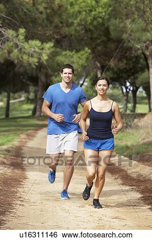 Couple running in park View Large Photo Image Stock Photograph - Couple running in park. Fotosearch