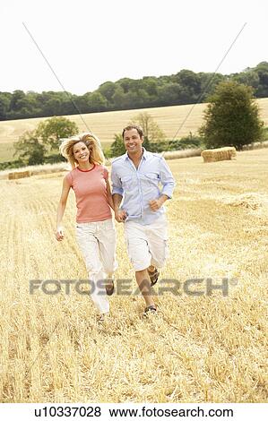 Couple Running Together Through Summer Harvested Field View Large Photo Image Stock Photo - Couple Running Together Through Summer Harvested Field. Fotosearch