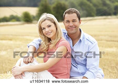 Couple Sitting On Straw Bales In Harvested Field View Large Photo Image Stock Photo - Couple Sitting On Straw Bales In Harvested Field. Fotosearch