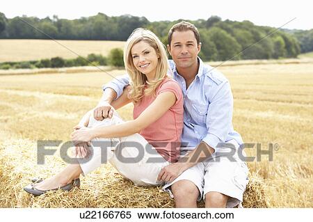 Couple Sitting On Straw Bales In Harvested Field View Large Photo Image Stock Photography - Couple Sitting On Straw Bales In Harvested Field. Fotosearch