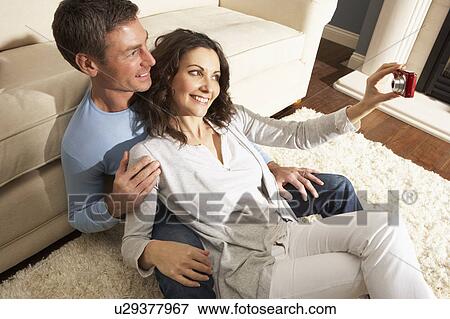 Couple Taking Photograph On Digital Camera At Home View Large Photo Image Stock Photo - Couple Taking Photograph On Digital Camera At Home . Fotosearch