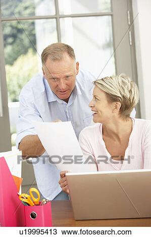 Stock Image - Couple Using Laptop At Home. Fotosearch