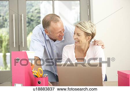 Couple Using Laptop At Home View Large Photo Image Stock Photo - Couple Using Laptop At Home. Fotosearch