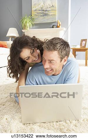 Couple Using Laptop Relaxing Laying On Rug At Home View Large Photo Image Stock Image - Couple Using Laptop Relaxing Laying On Rug At Home. Fotosearch