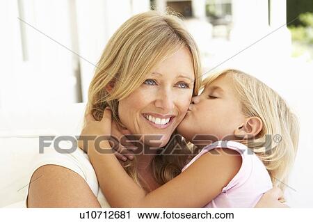 Daughter Giving Mother Kiss Relaxing On Sofa View Large Photo Image Stock Image - Daughter Giving Mother Kiss Relaxing On Sofa. Fotosearch