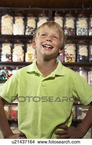 Picture - Excited Boy Standing In Sweet Shop. Fotosearch