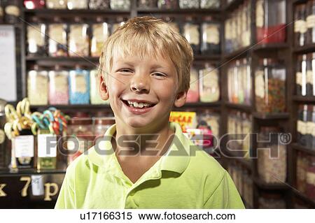 Stock Photography - Excited Boy Standing In Sweet Shop. Fotosearch