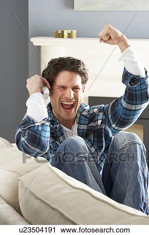 Excited Man Sitting On Sofa At Home Talking On Phone View Large Photo Image Stock Image - Excited Man Sitting On Sofa At Home Talking On Phone. Fotosearch