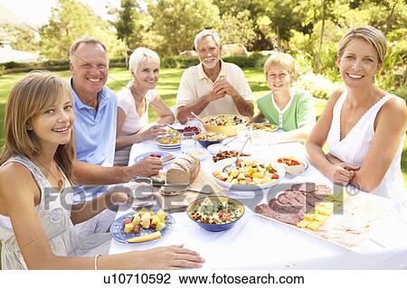 Extended Family Enjoying Meal In Garden View Large Photo Image Stock Image - Extended Family Enjoying Meal In Garden. Fotosearch