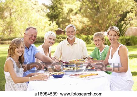 Extended Family Enjoying Meal In Garden View Large Photo Image Stock Photo - Extended Family Enjoying Meal In Garden. Fotosearch