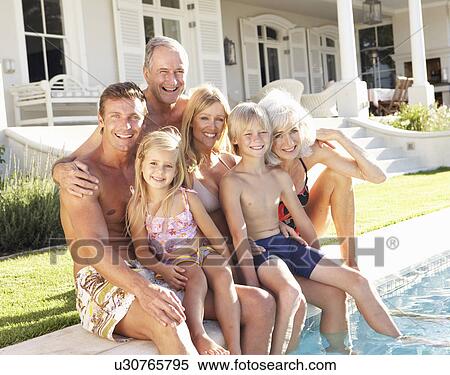 Stock Photography - Extended Family Outside Relaxing By Swimming Pool. Fotosearch