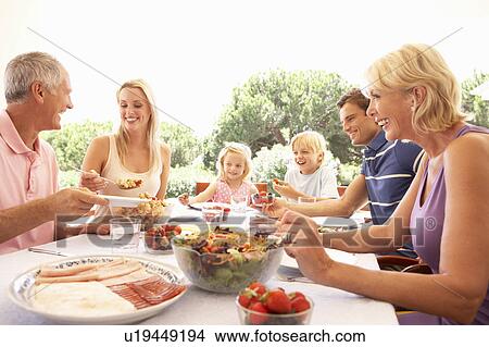 Extended family, parents, grandparents and children, eating outdoors View Large Photo Image Picture - Extended family, parents, grandparents and children, eating outdoors. Fotosearch