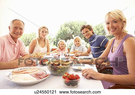 Extended family, parents, grandparents and children, eating outdoors View Large Photo Image Stock Image - Extended family, parents, grandparents and children, eating outdoors. Fotosearch