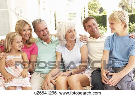 Stock Photograph - Extended Family Relaxing Together On Sofa. Fotosearch