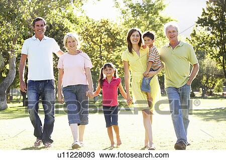 Stock Image - Extended Group Portrait Of Family Enjoying Walk In Park. Fotosearch