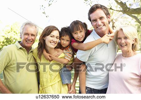 Stock Image - Extended Group Portrait Of Family Enjoying Day In Park. Fotosearch