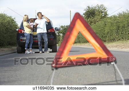 Stock Photography - Family Broken Down On Country Road With Hazard Warning Sign In Foreground. Fotosearch