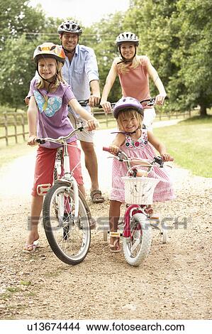 Family Cycling In Countryside Wearing Safety Helmets View Large Photo Image Picture - Family Cycling In Countryside Wearing Safety Helmets. Fotosearch