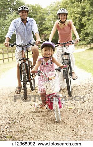 Family Cycling In Countryside Wearing Safety Helmets View Large Photo Image Stock Image - Family Cycling In Countryside Wearing Safety Helmets. Fotosearch