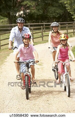 Family Cycling In Countryside Wearing Safety Helmets View Large Photo Image Stock Image - Family Cycling In Countryside Wearing Safety Helmets. Fotosearch