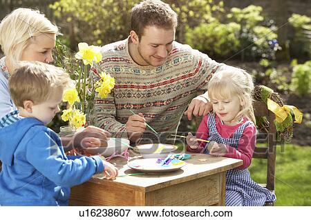 Stock Photo - Family Decorating Easter Eggs On Table Outdoors . Fotosearch