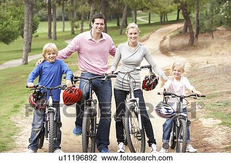 Family enjoying bike ride in park View Large Photo Image Stock Image - Family enjoying bike ride in park. Fotosearch