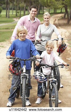 Stock Image - Family enjoying bike ride in park. Fotosearch
