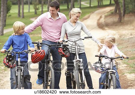 Stock Image - Family enjoying bike ride in park. Fotosearch