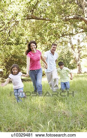 Stock Image - Family Enjoying Walk In Park. Fotosearch