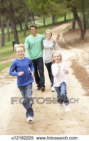 Family enjoying walk in park View Large Photo Image Stock Photography - Family enjoying walk in park. Fotosearch