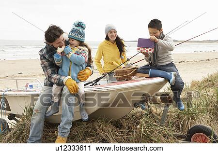 Family Group Sitting On Boat With Fishing Rod On Winter Beach View Large Photo Image Stock Image - Family Group Sitting On Boat With Fishing Rod On Winter Beach. Fotosearch