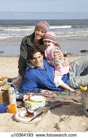 Stock Image - Family Having Barbeque On Winter Beach. Fotosearch